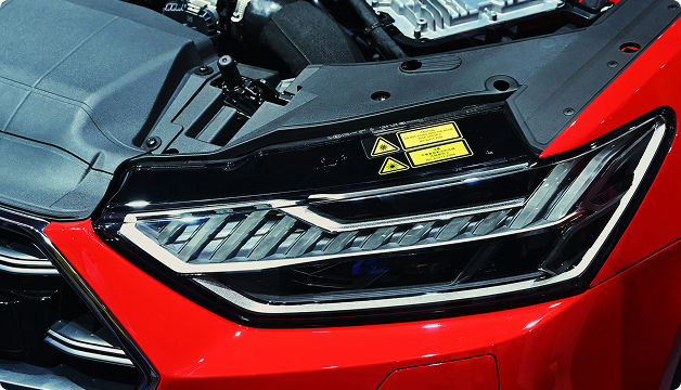 Close-up of a red car’s front LED headlight assembly.